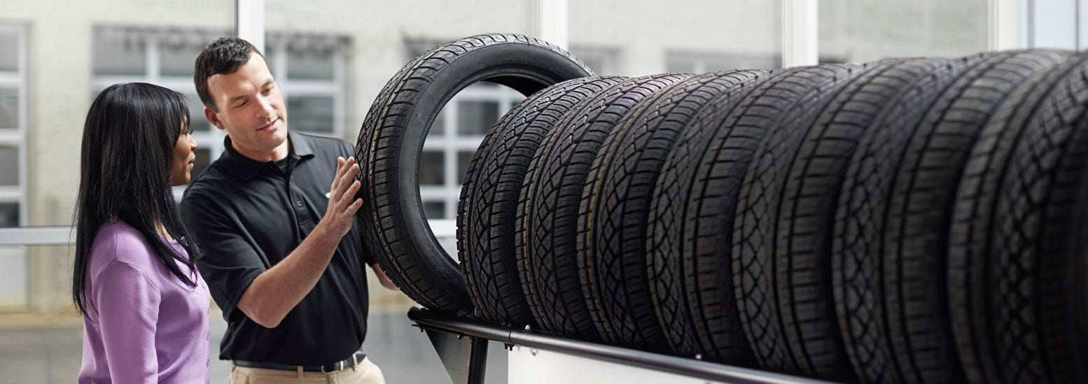 Subaru service representative showing customer a tire. | Victory Subaru in Somerset NJ